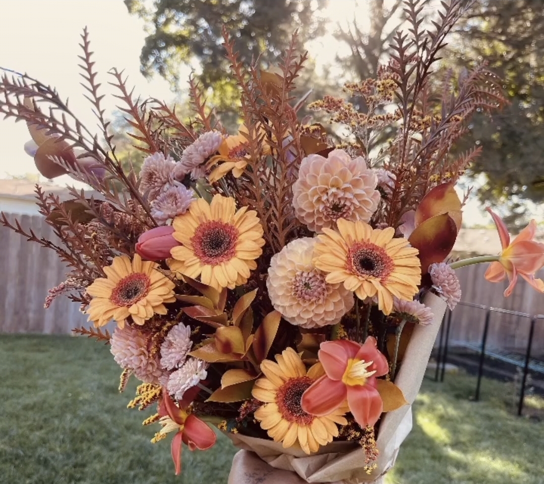 A wrapped bouquet of gerbera daisies, dahlias and mums from the flower shed